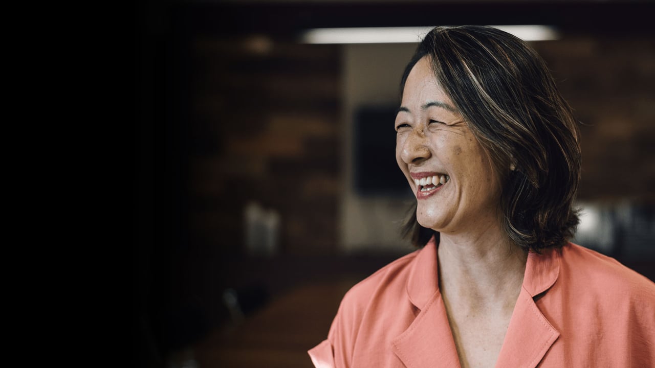 Professional woman, ageless, captured moment, smiling authentically off camera